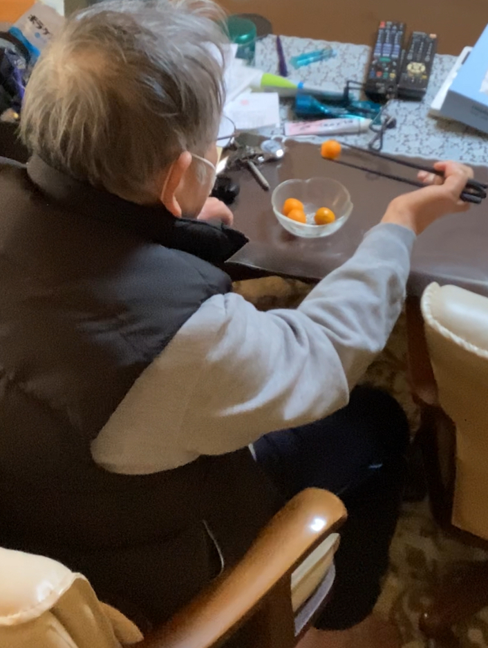 ばね付き箸を使用しての食事動作練習の様子。掴む力が少ない方などに使用する道具（自助具）です。